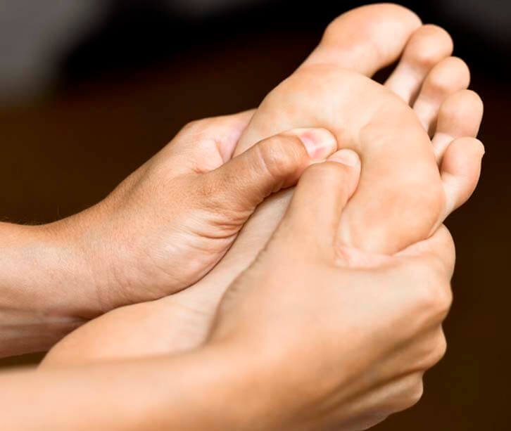kellypazelli podologa reflexologia podal mostrando um pé recebendo reflexologia podal por duas mãos - kelly pazelli podóloga indaiatuba interior de sao paulo
